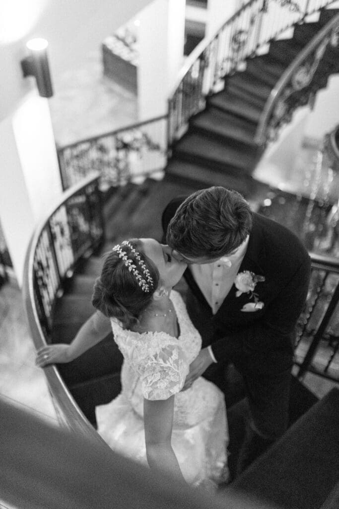 bride and groom kissing on a stair case