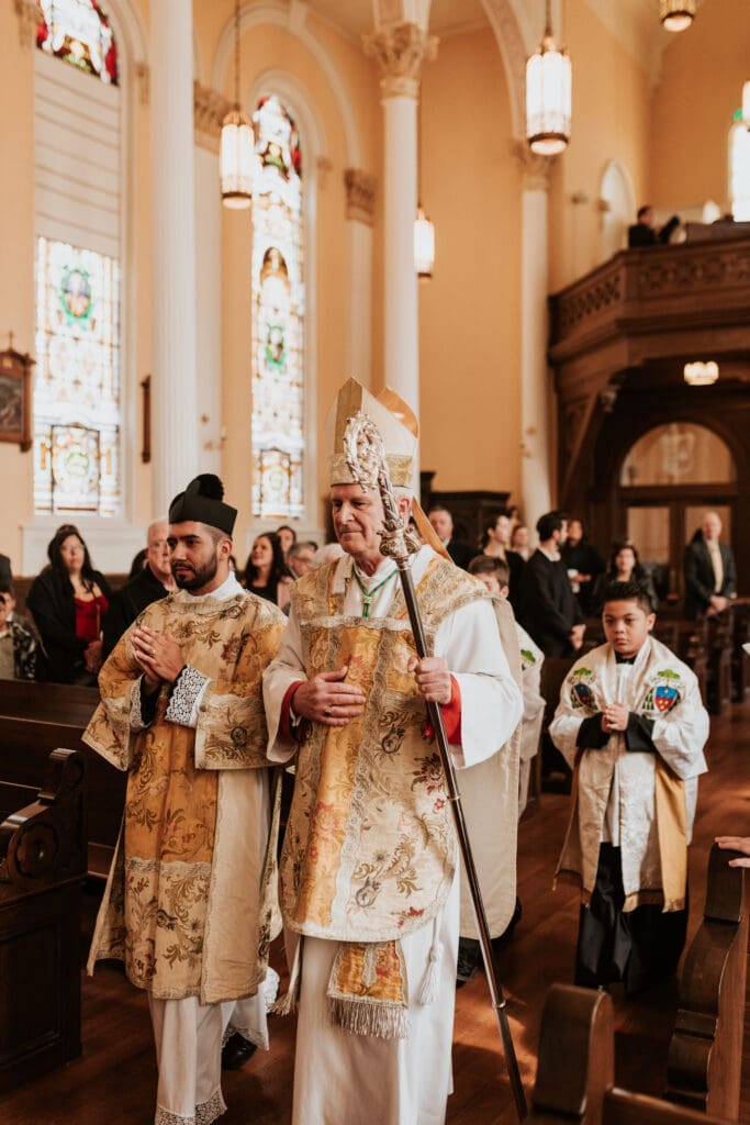 an archbishop walking down the aisle in a wedding ceremony