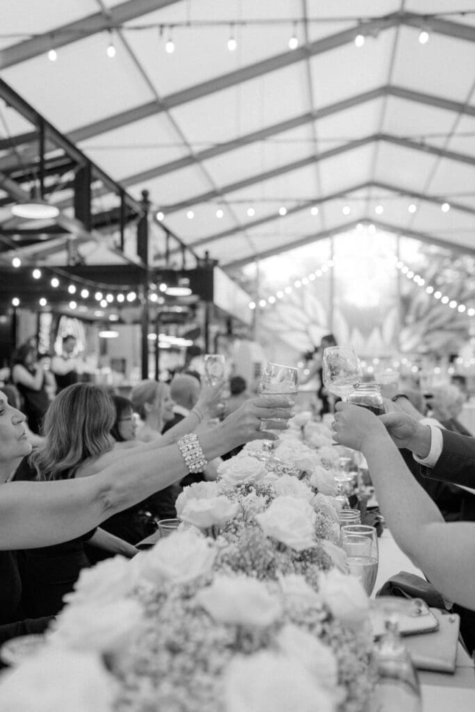 hands of guests toasting glasses at a speech