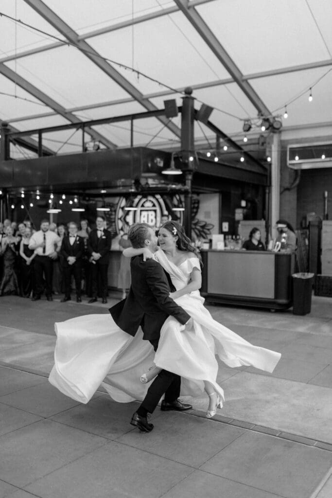 a groom spinning his bride around the dance floor