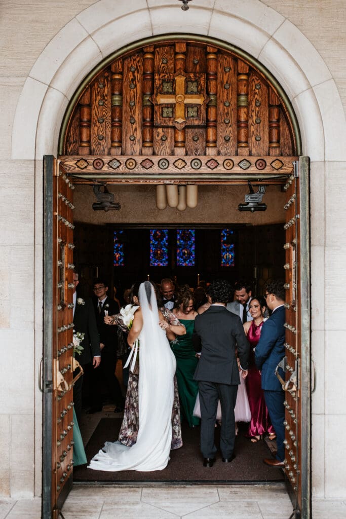 newly married couple greets guests after the wedding ceremony mass at Gesu Catholic Church in Detroit Michigan