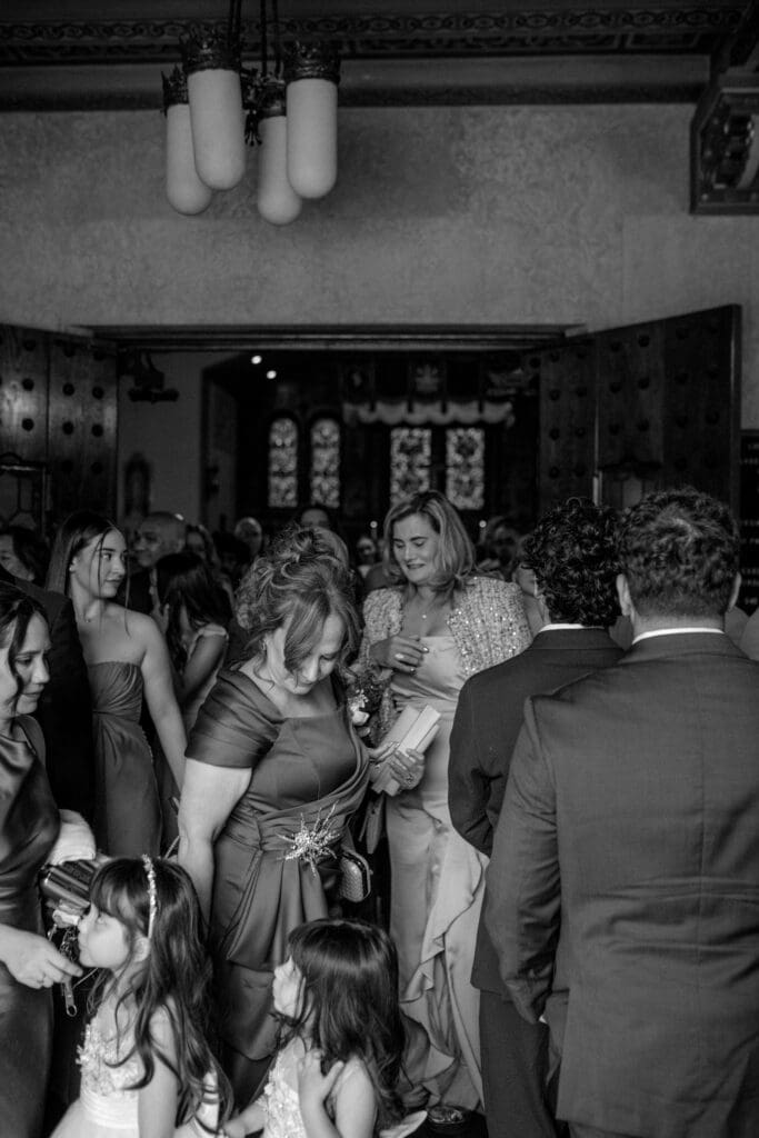 Black and white photo of all the guests mingling after the ceremony at Gesu Catholic Church in Detroit Michigan
