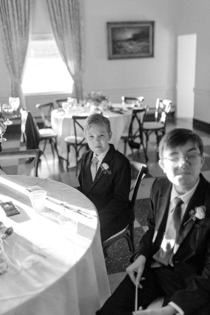 little brother of the bride sneers at the camera inside Detroit yacht club ballroom