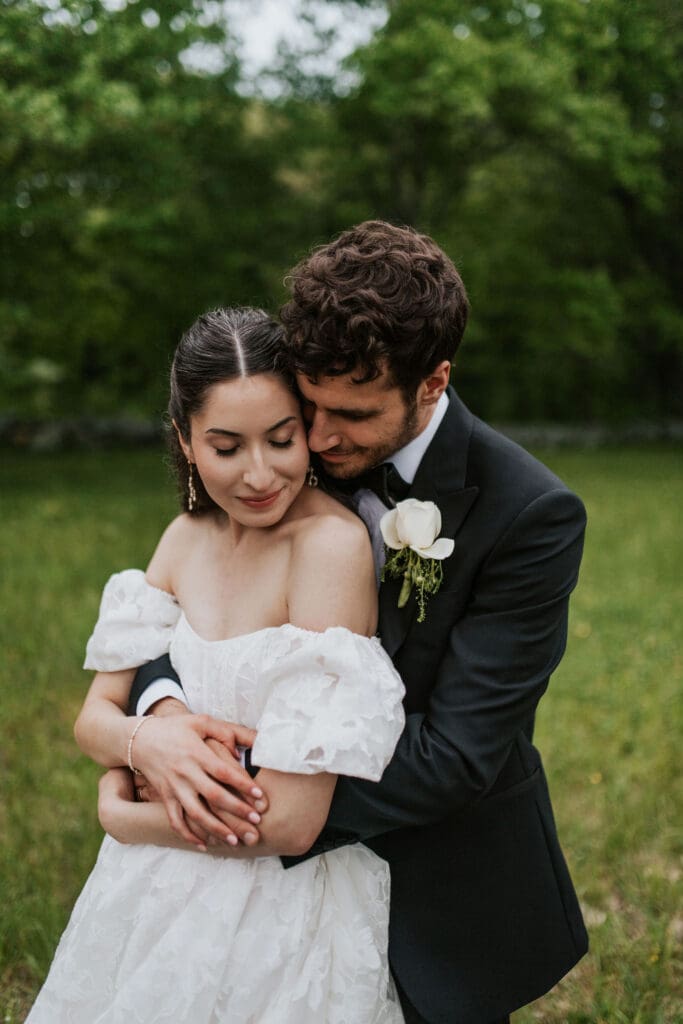 groom embracing his bride in a field