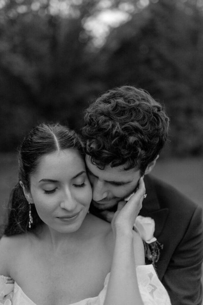 a man embraces his bride while she holds his face