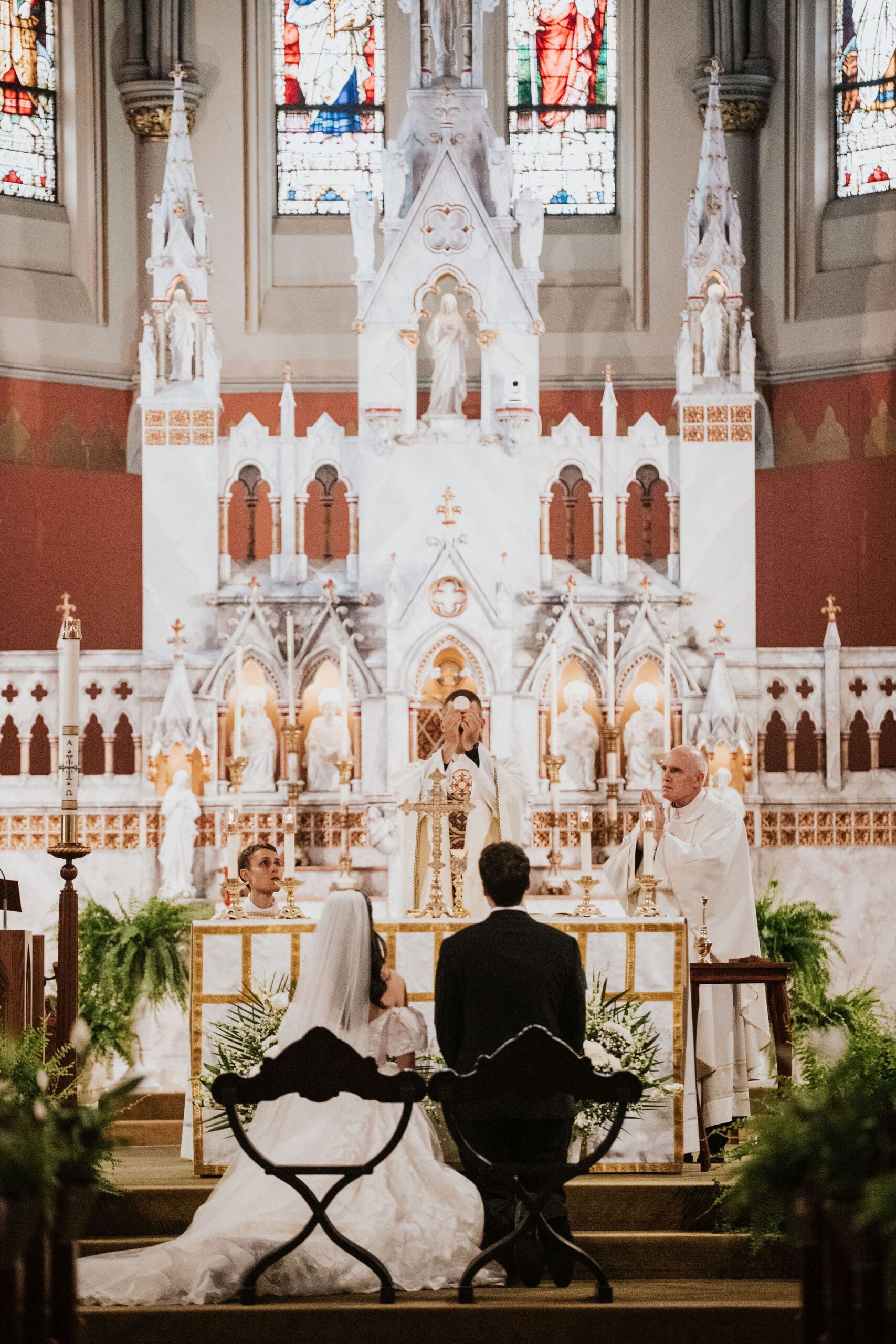 A bride and groom sitting at the altar of the St. Mary of the Assumption Parish