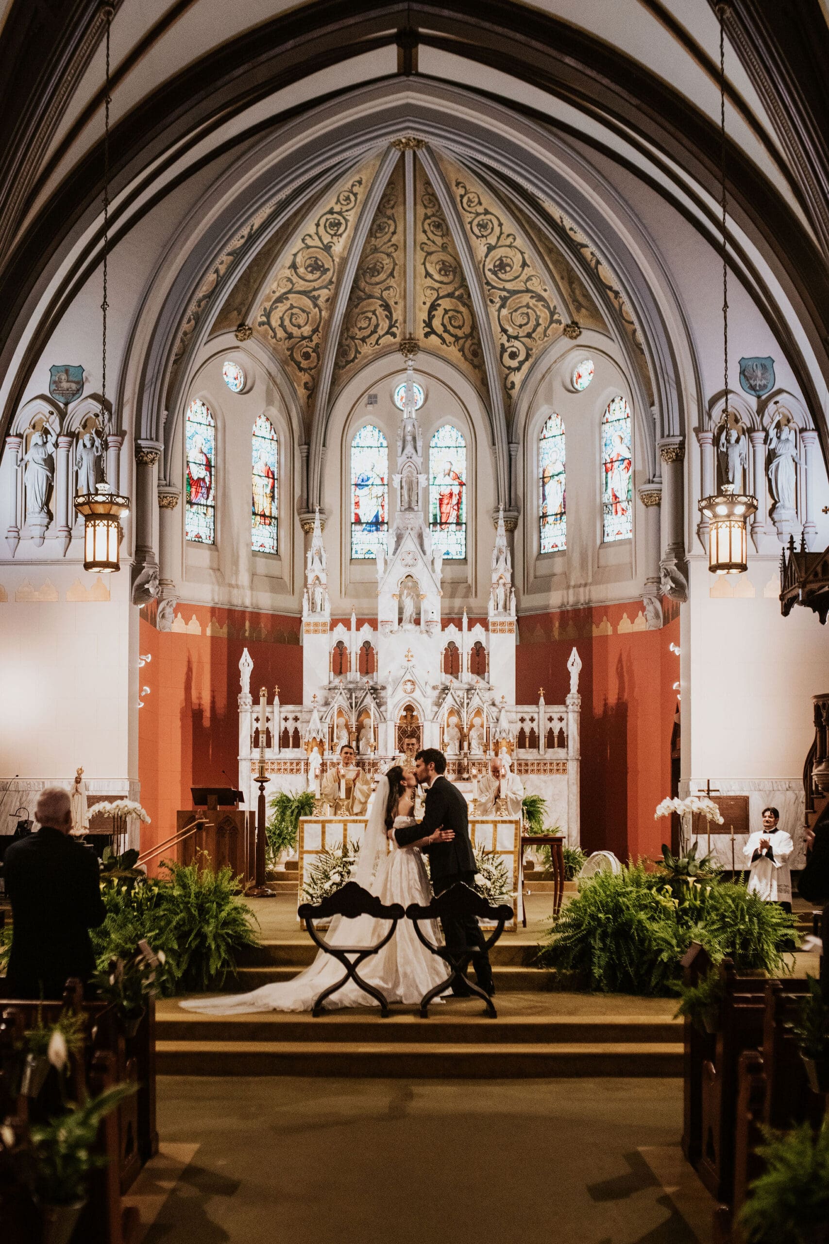 A bride and groom kissing as they are introduced as man and wife at the St. Mary of the Assumption Parish