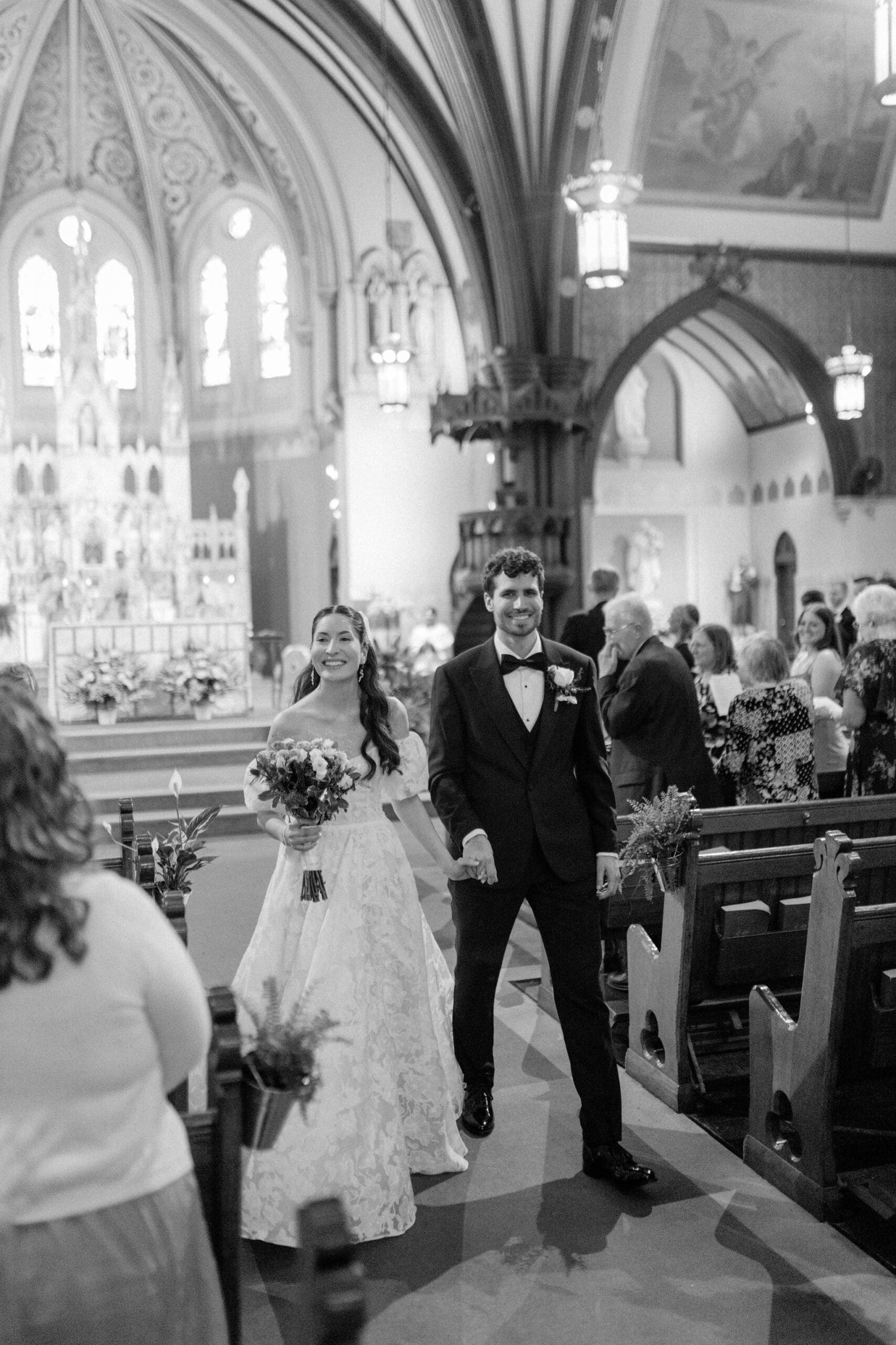 A bride and groom leaving as man and wife after their St. Mary Of Assumption Parish Catholic Church ceremony