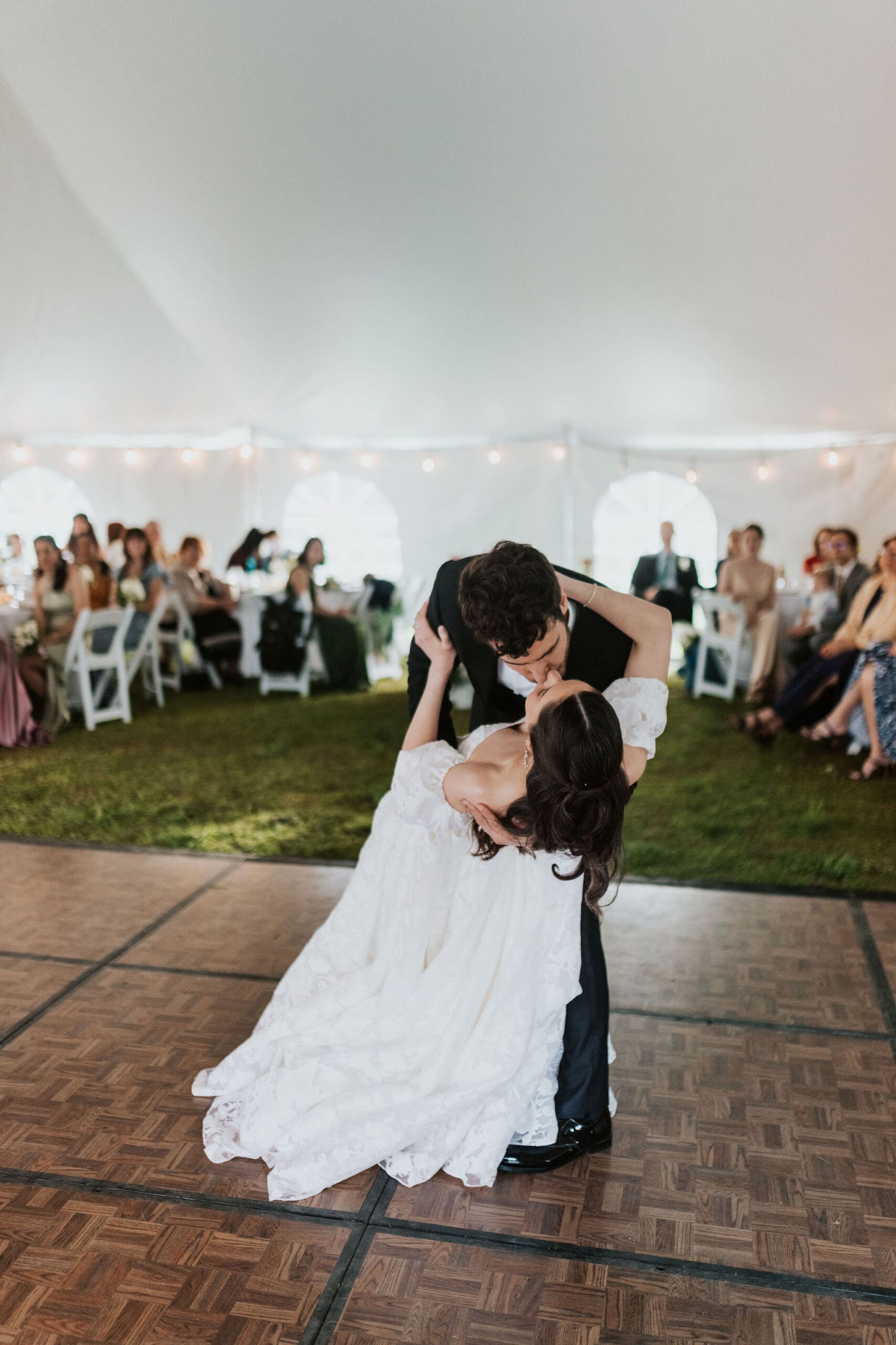 a groom dipping his bride for a kiss after their first dance in boston