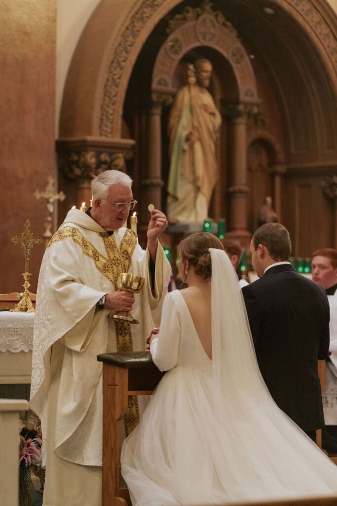 Bride and groom receiving the eucharist for the first time as husband and wife at St. Benedict's parish in Atchison, Kansas