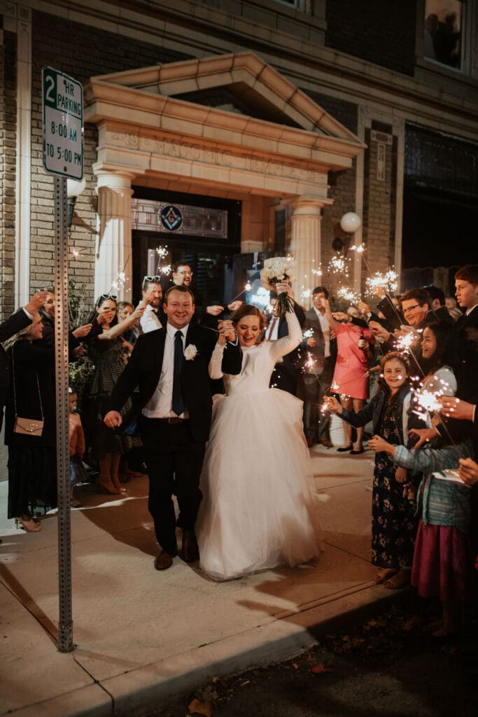 Newlyweds walk through sparkling send-off surrounded by guests in Atchison Kansas