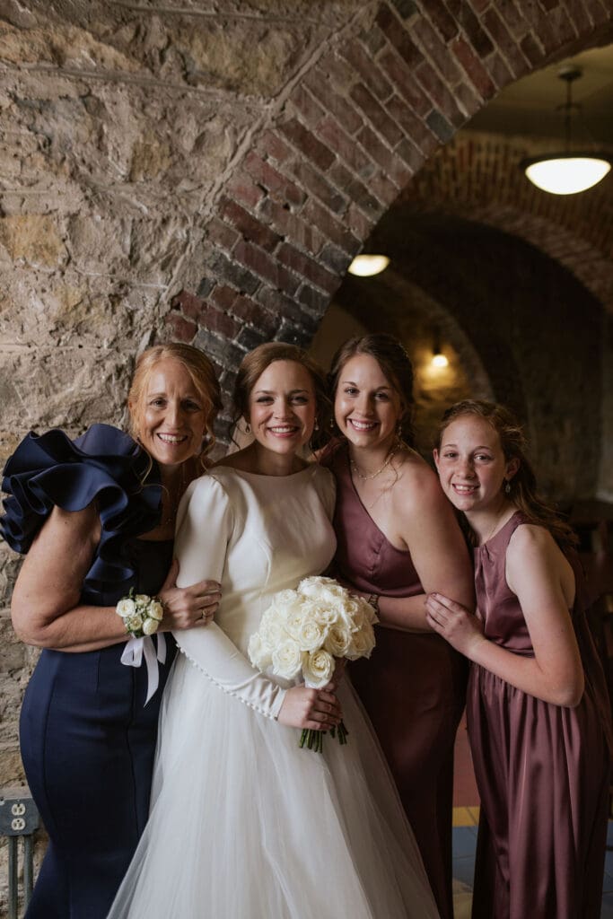 Bride and sisters and her mother smiling portrait before wedding ceremony