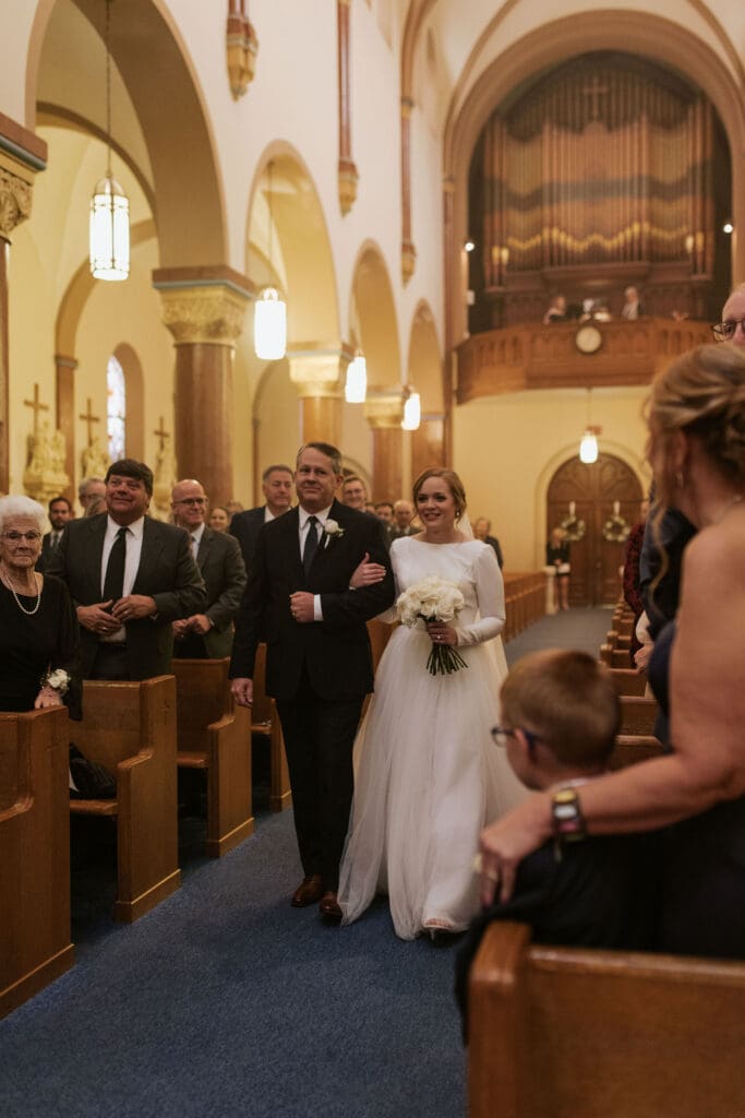 Bride walking down the aisle at St. Benedict’s Parish in Atchison KS