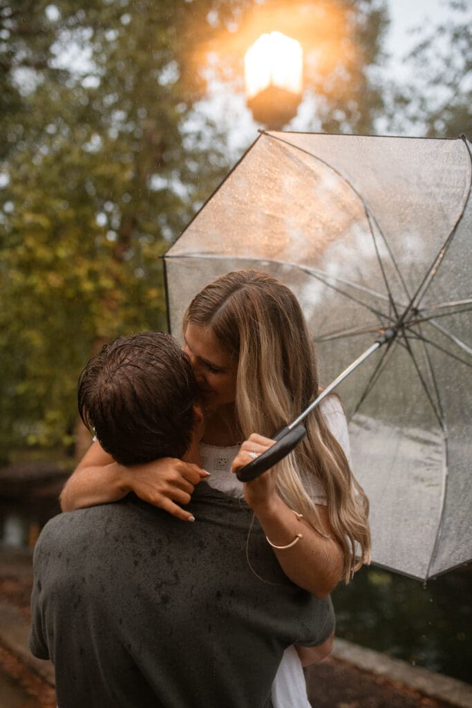 woman whispering into a mans ear with an umbrella