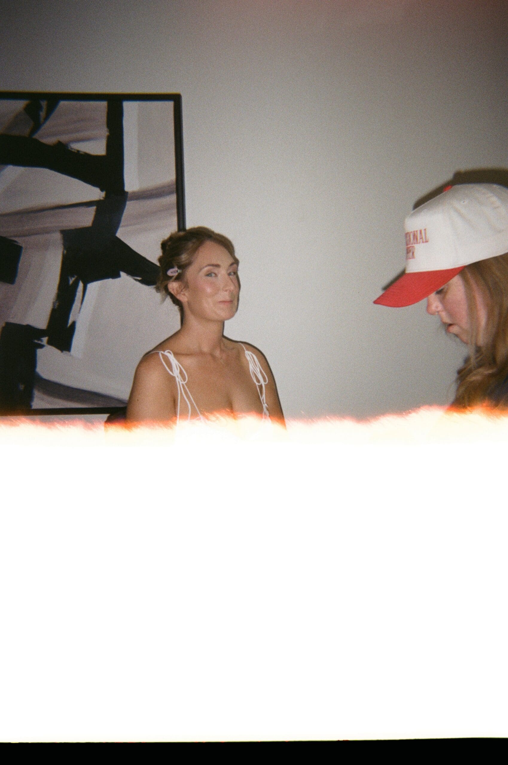 Bridal hair and makeup artist working with a bride during wedding morning preparations in a softly lit room