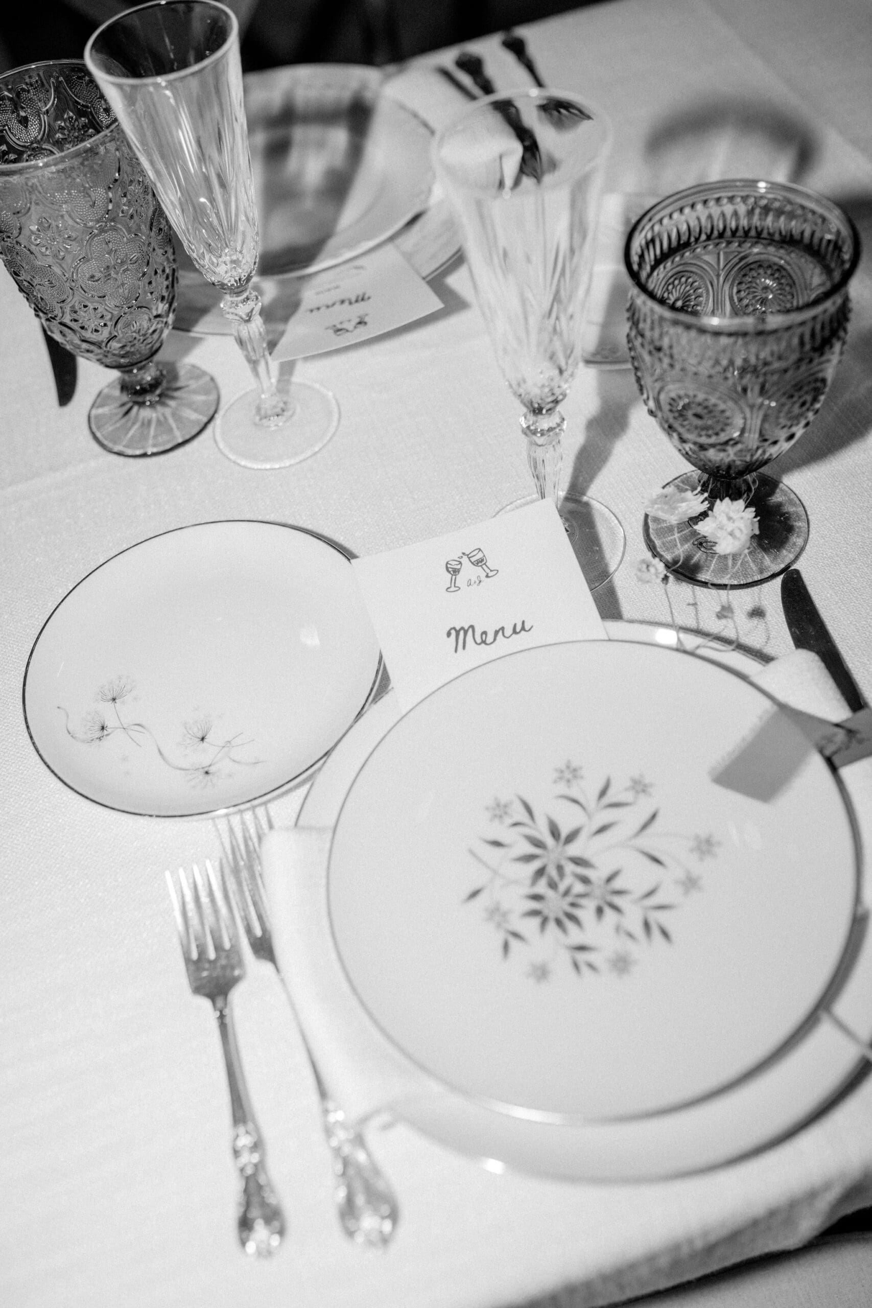 Vintage glassware and menu detail at wedding reception table setting