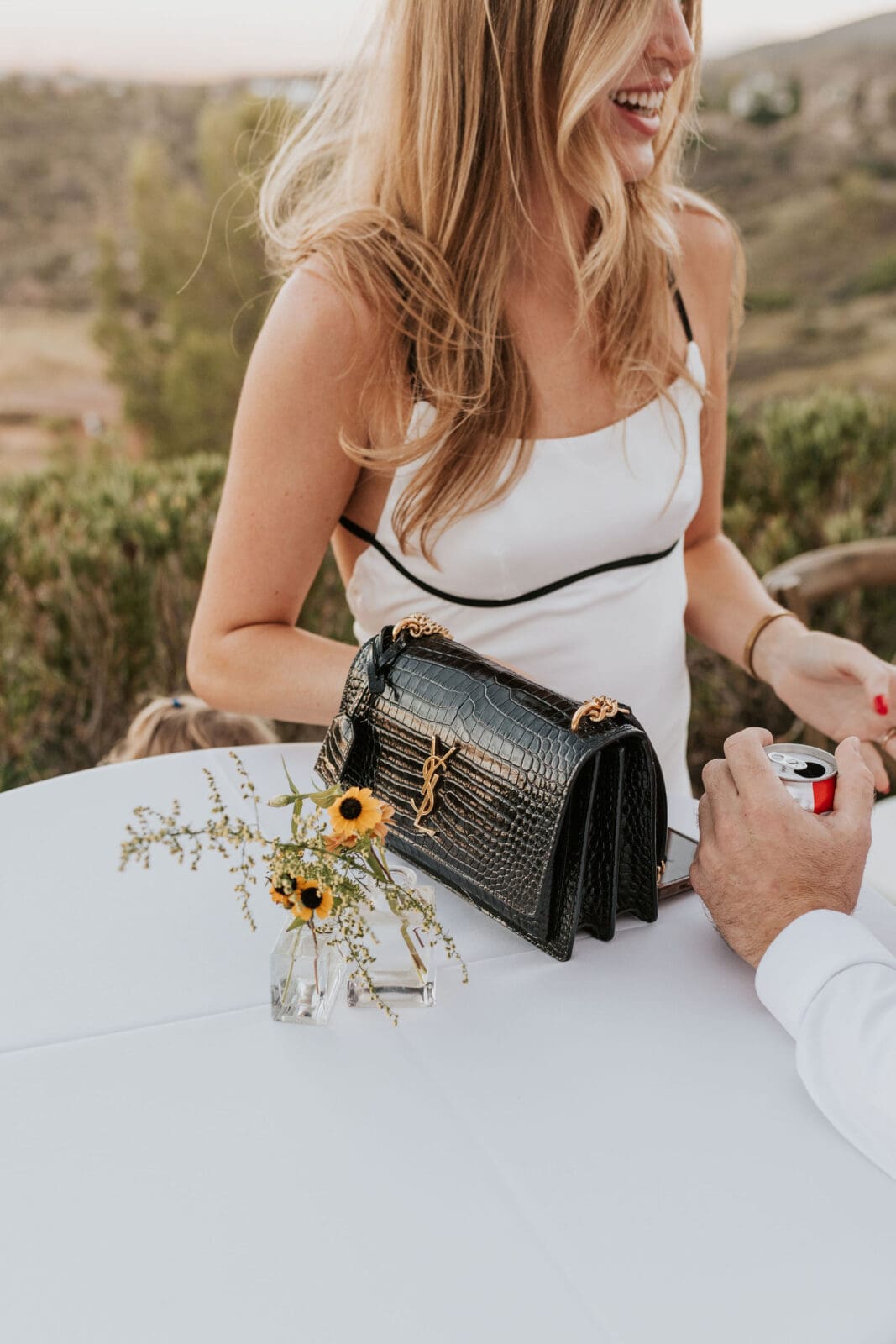 Wedding guest detail with black handbag and floral centerpiece during Arizona micro wedding reception
