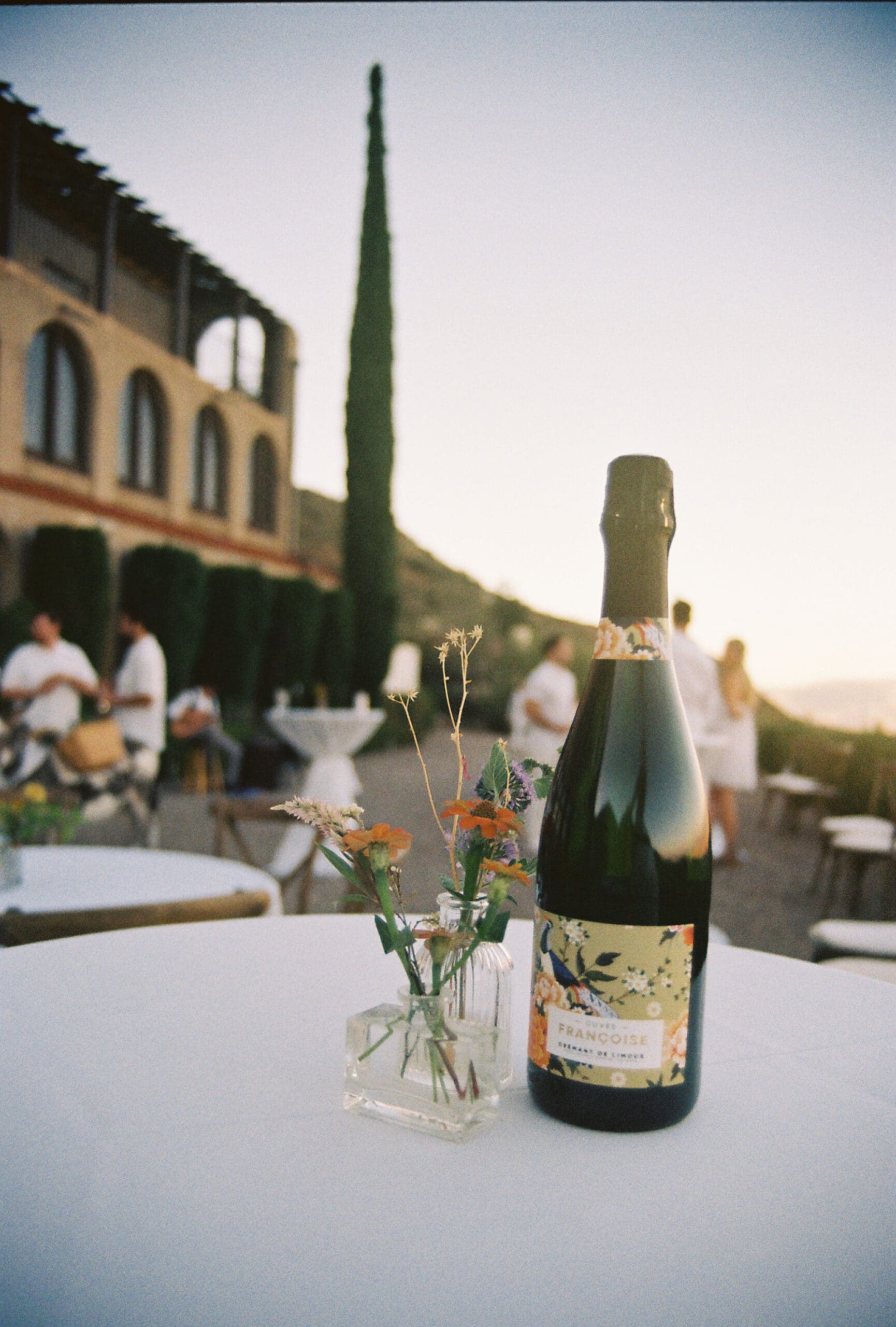 Champagne bottle and floral detail on cocktail table at The Little Daisy Jerome during Arizona wedding welcome night