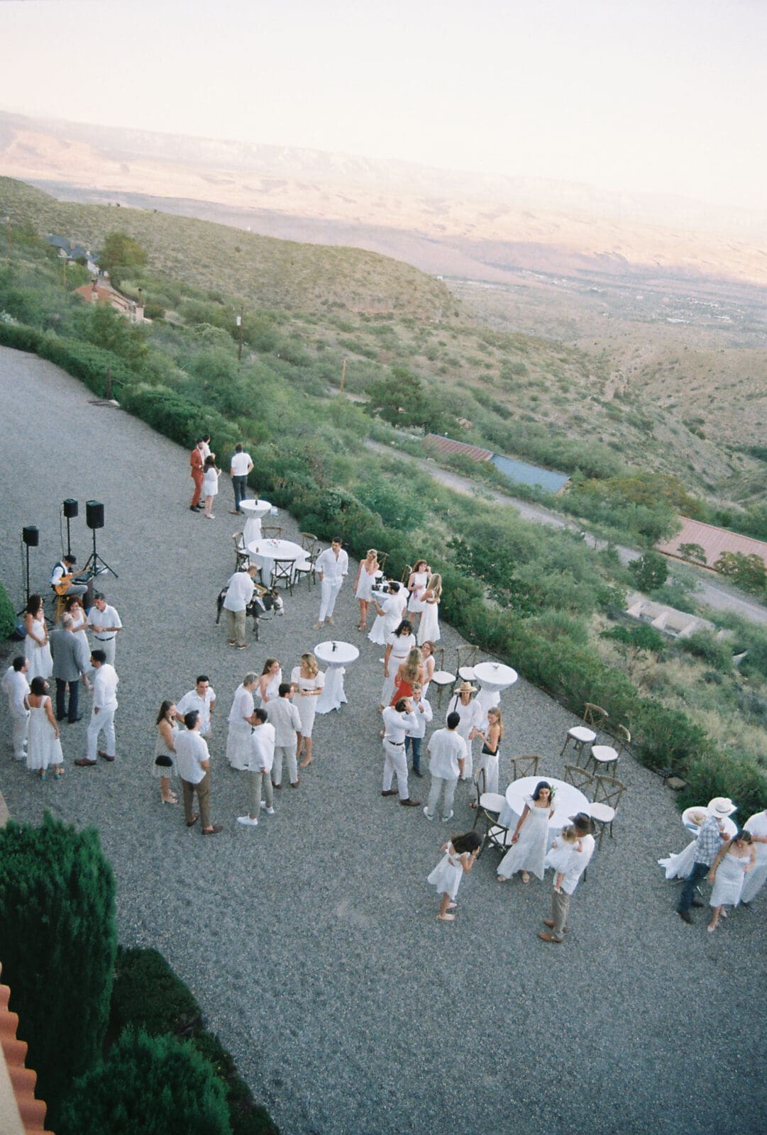 Welcome party overlooking the valley at The Little Daisy Jerome with guests dressed in white during sunset in Jerome Arizona