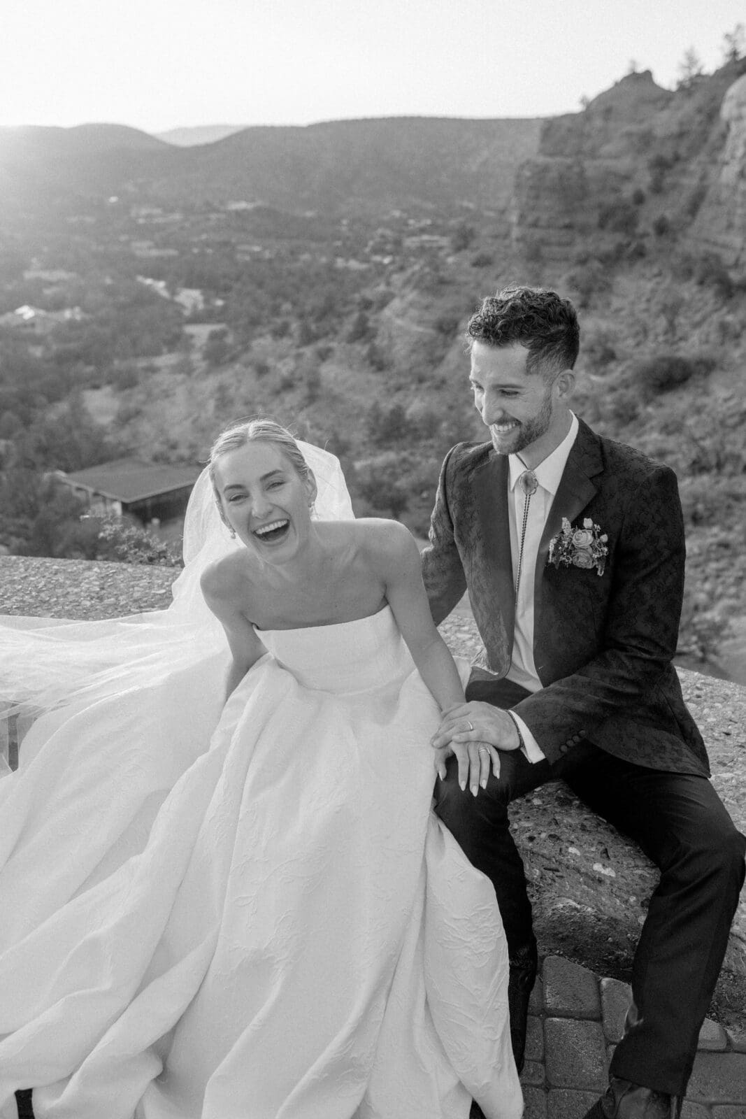 Bride and groom laughing together overlooking Sedona red rock landscape