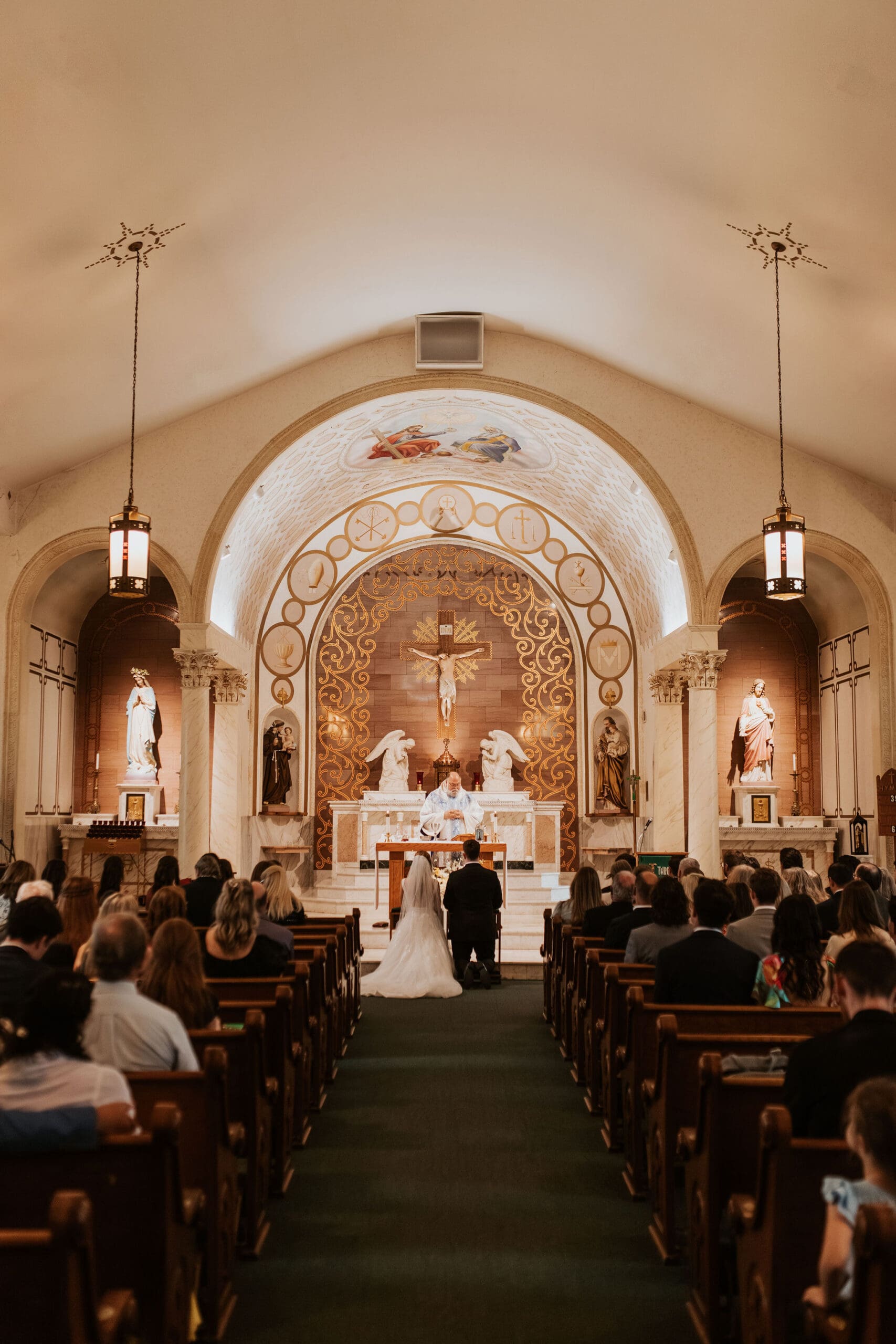 intimate catholic church wedding ceremony inside Holy Trinity with warm light
