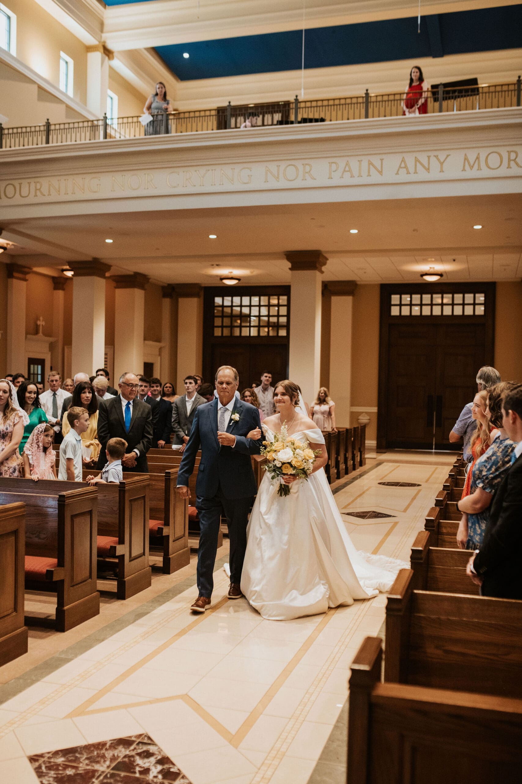 bride walking down the aisle at St. Michael the Archangel Catholic wedding ceremony a very classic catholic churches in Kansas City