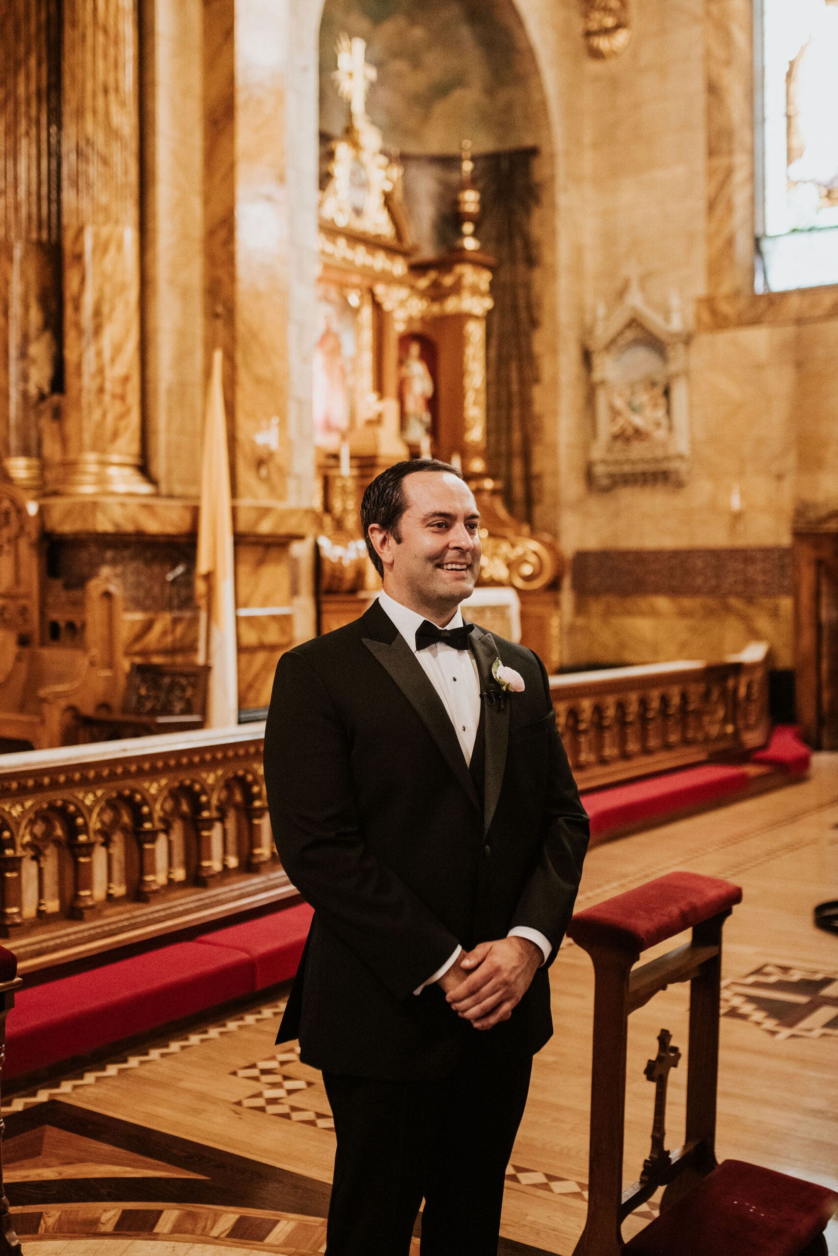 Groom waiting at the altar during Saint John Cantius Chicago wedding ceremony inside ornate Catholic church.