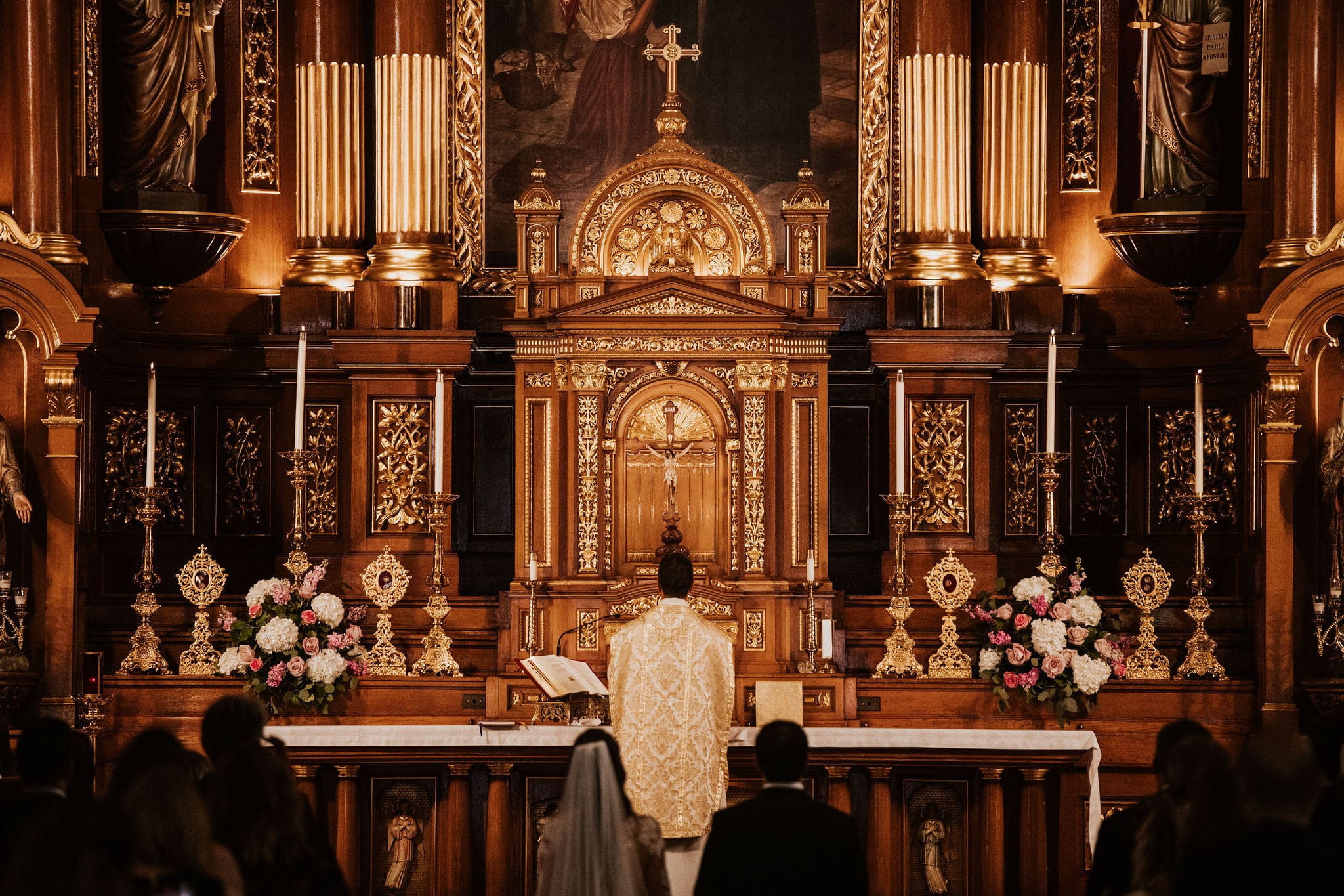 Priest standing at the ornate altar during Catholic wedding Mass at Saint John Cantius Chicago.