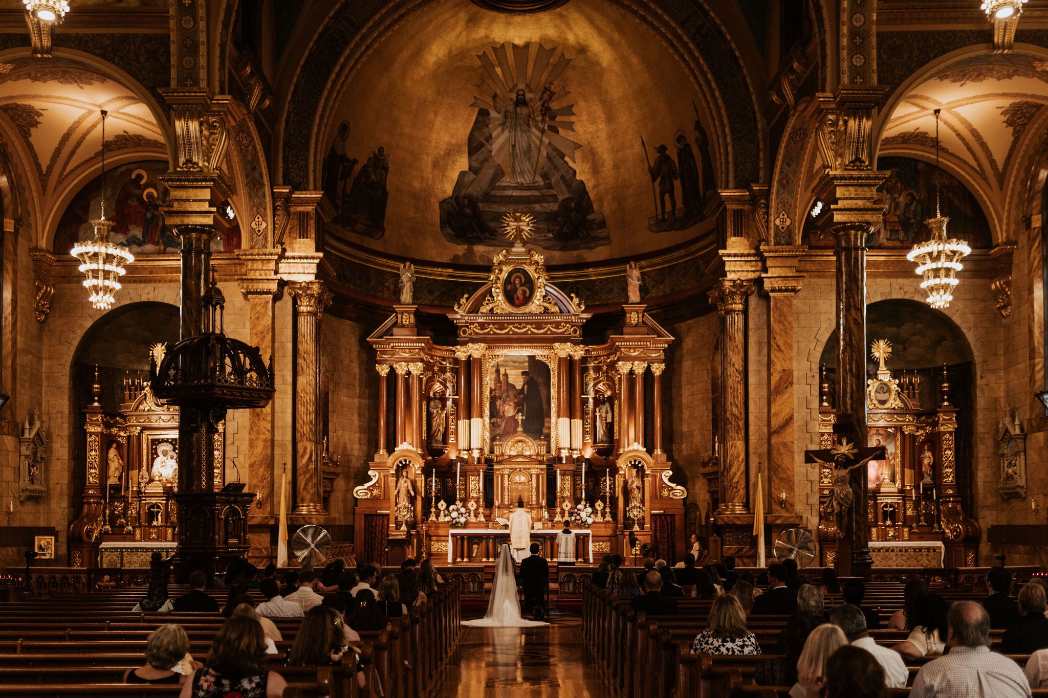 Saint John Cantius Chicago wedding ceremony with priest and couple at altar.