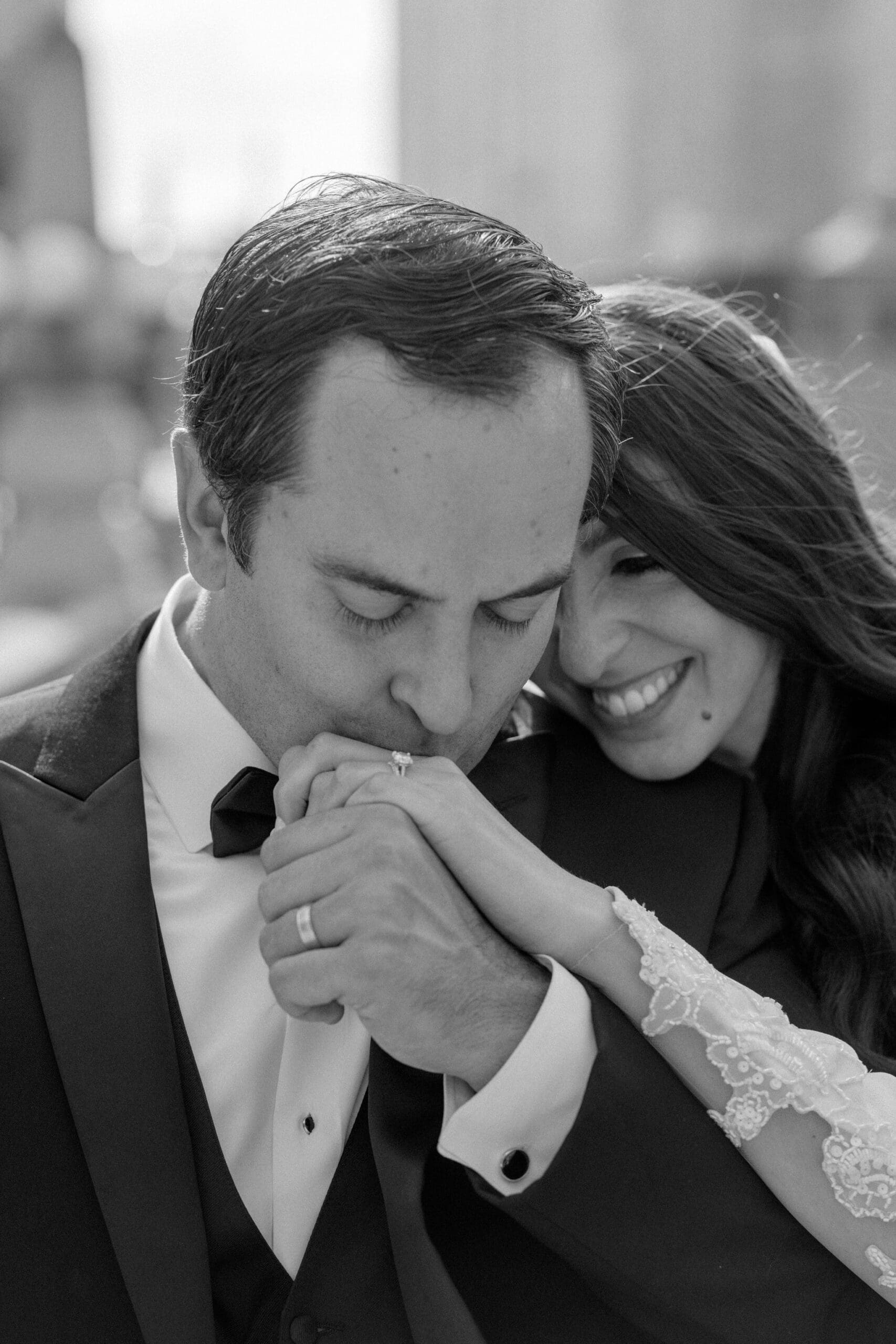Black and white portrait of groom kissing bride’s hand during Chicago wedding portraits.