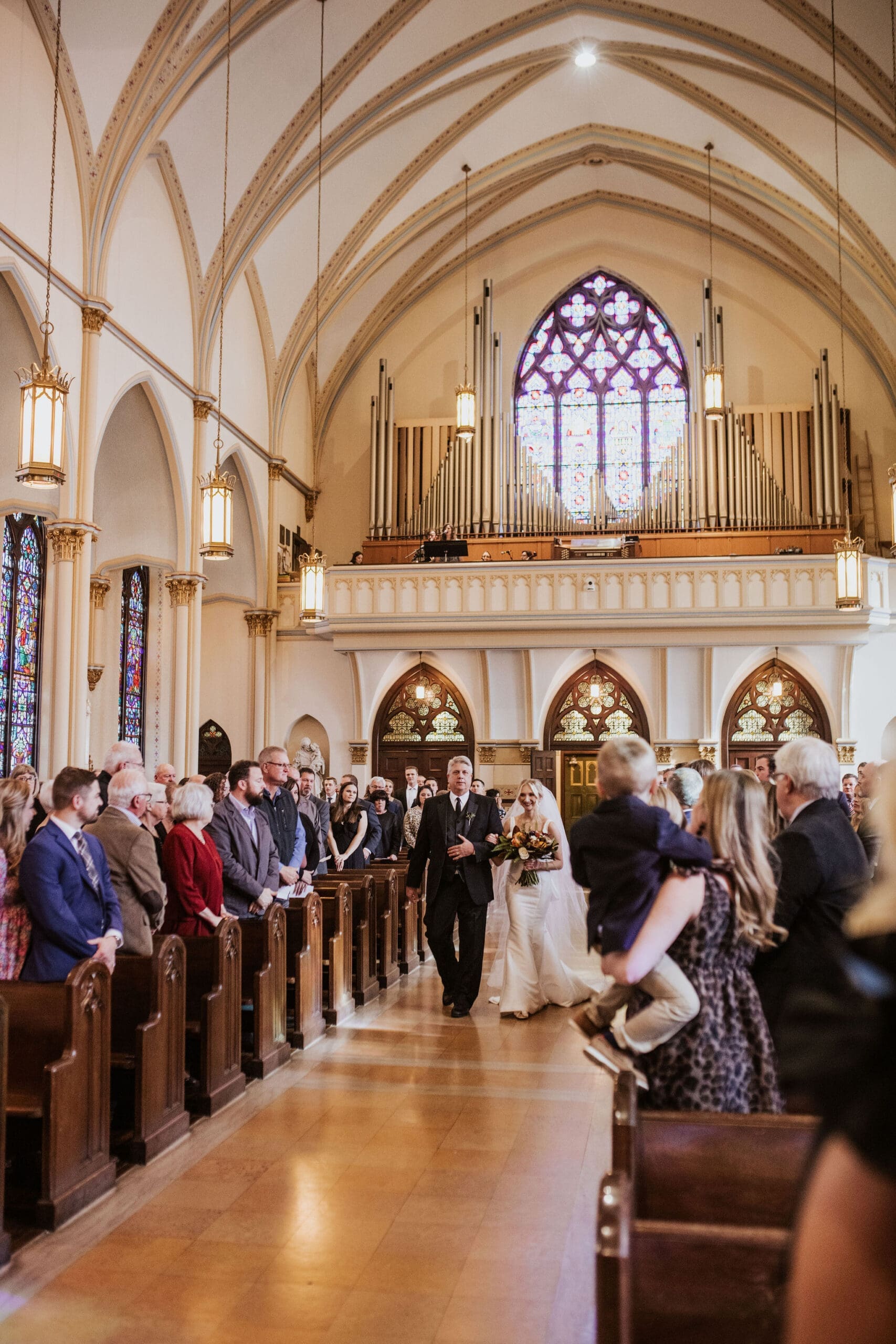 Kansas City Catholic church wedding ceremony featuring grand arches, ornate altar details, and historic architecture