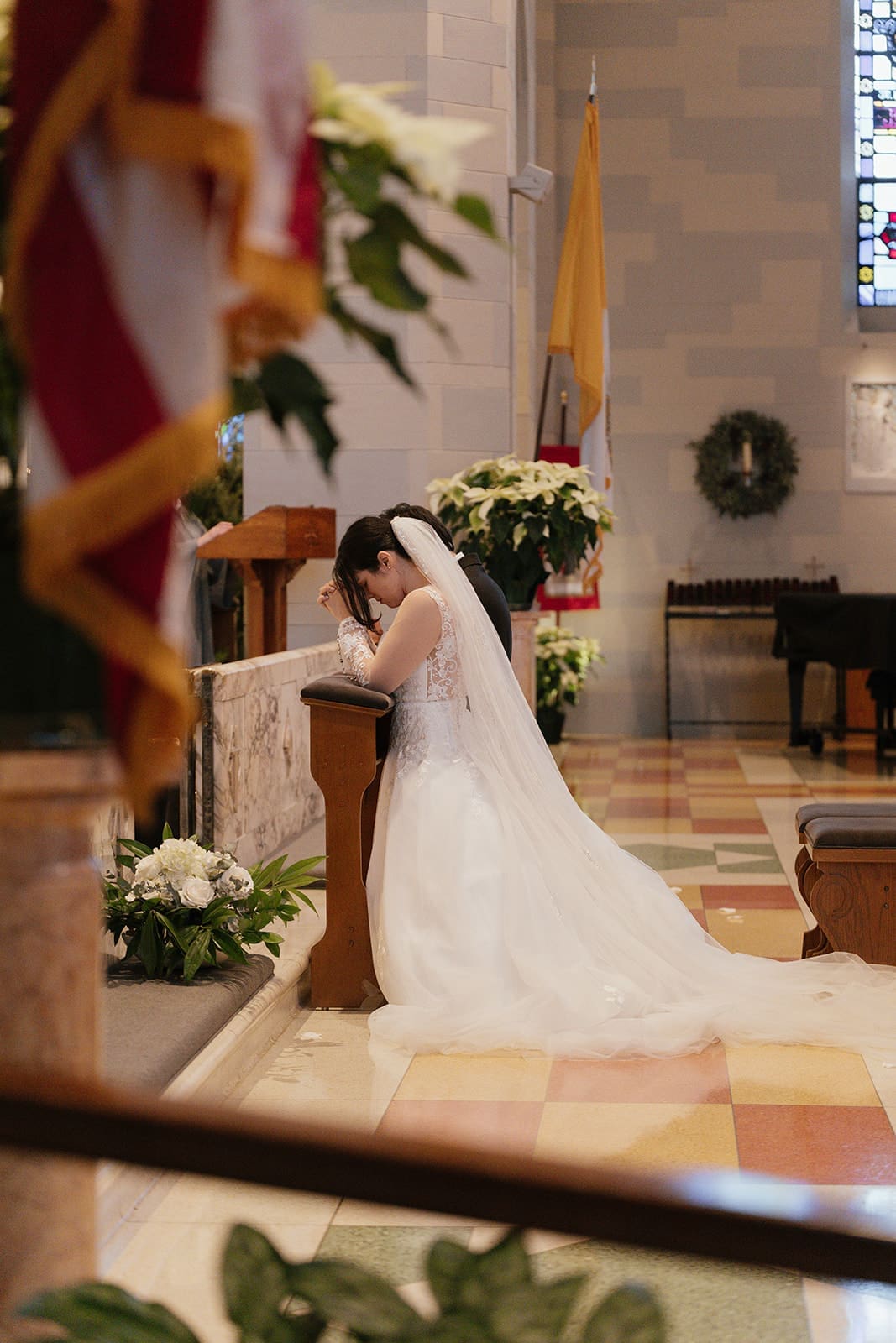 a bride and groom praying on a kneeler at st. ann's catholic church in washington DC