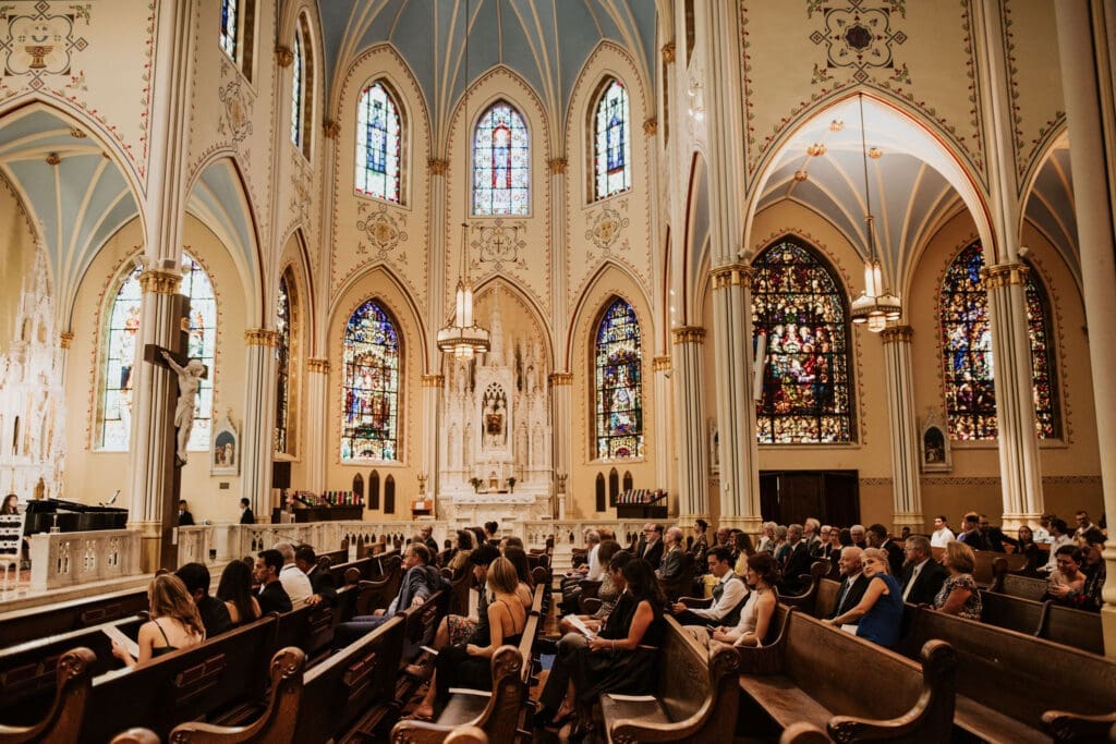 Catholic wedding ceremony at a Kansas City Catholic church filled with colorful stained glass and timeless architecture