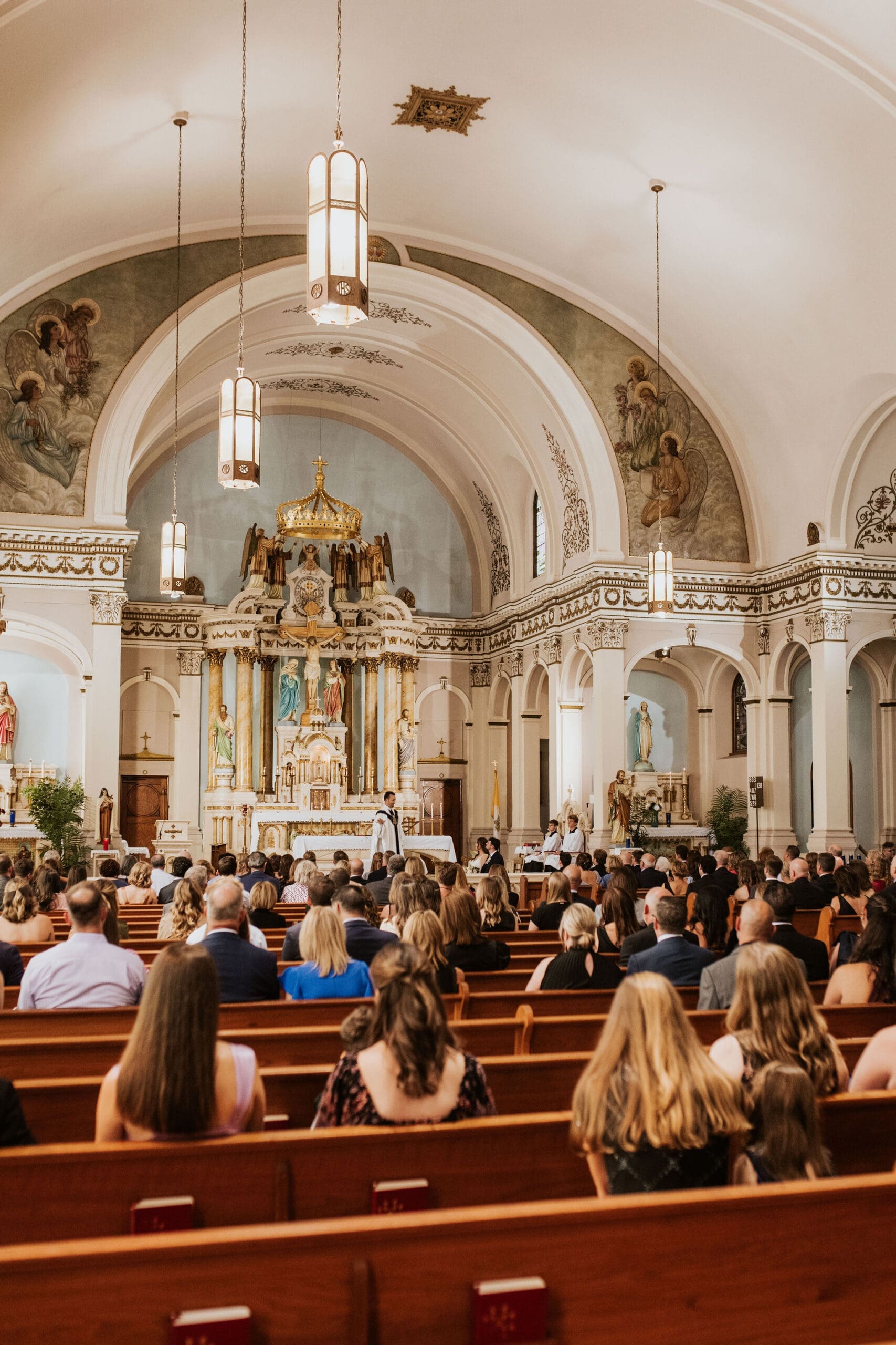 Classic Catholic church interior filled with wedding guests during a timeless and emotional wedding ceremony.