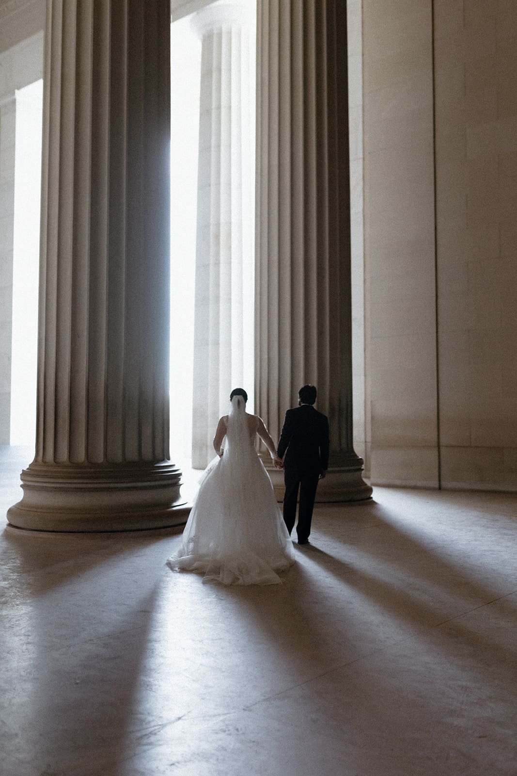 washington dc wedding photos couple walking through lincoln memorial columns
