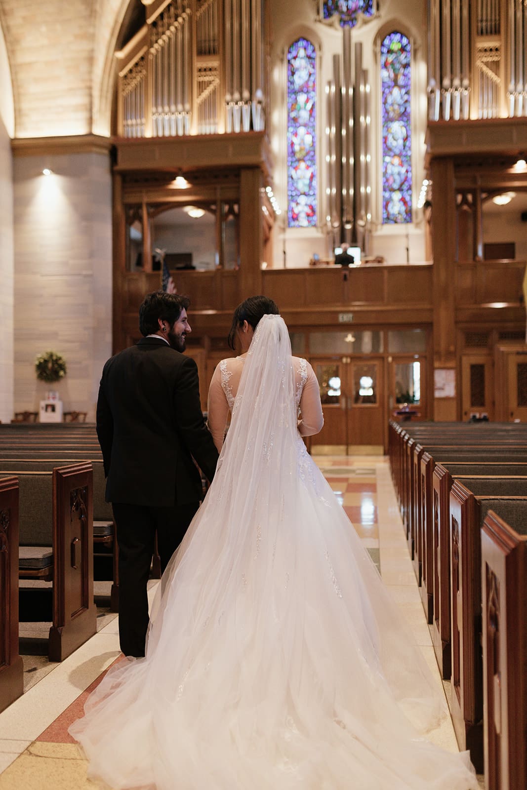 A bride and groom walking down the aisle after their wedding ceremony at st ann’s catholic church