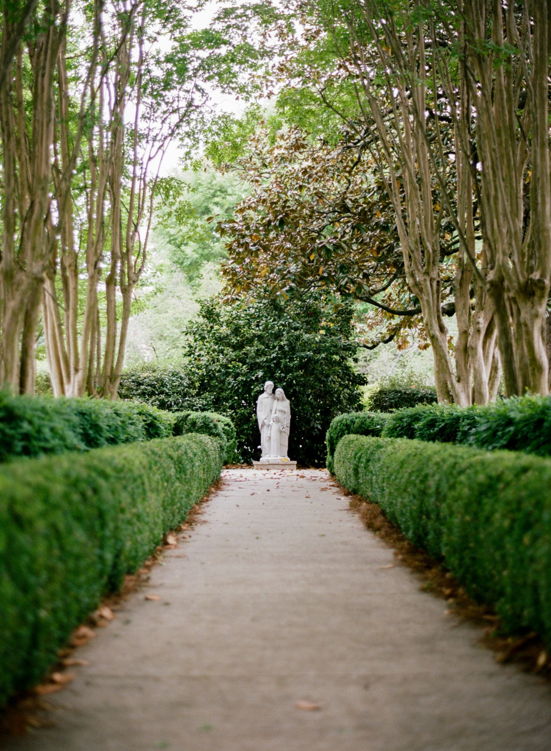 Garden pathway and statue details captured during romantic church wedding portraits