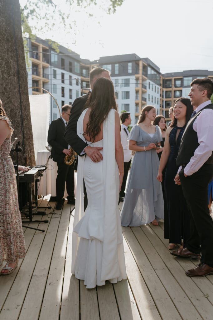 Bride and groom mingling with guests during outdoor wedding cocktail hour at sunset