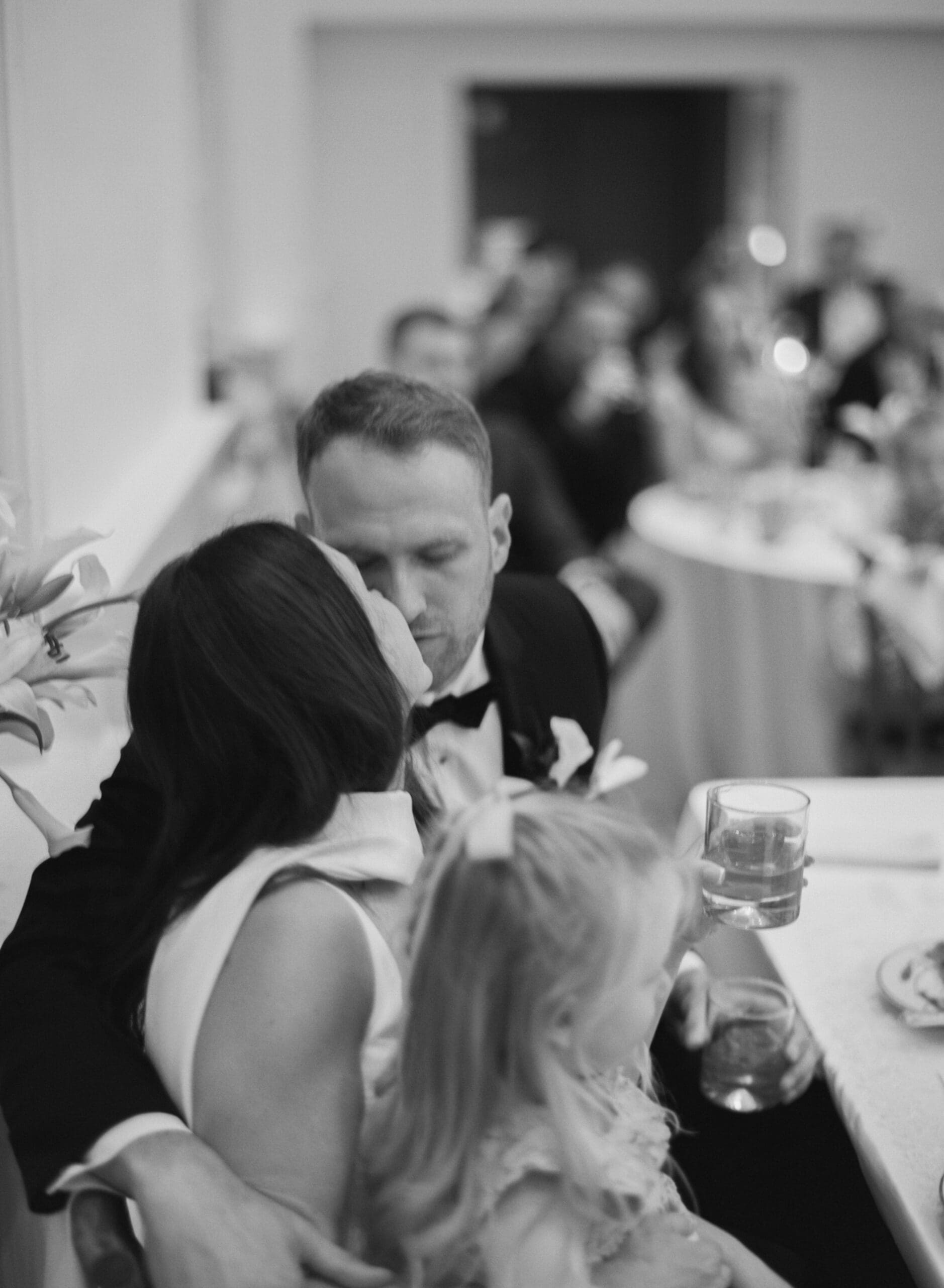 Romantic black and white wedding reception moment with bride and groom sharing an intimate kiss during elegant Atlanta wedding celebration