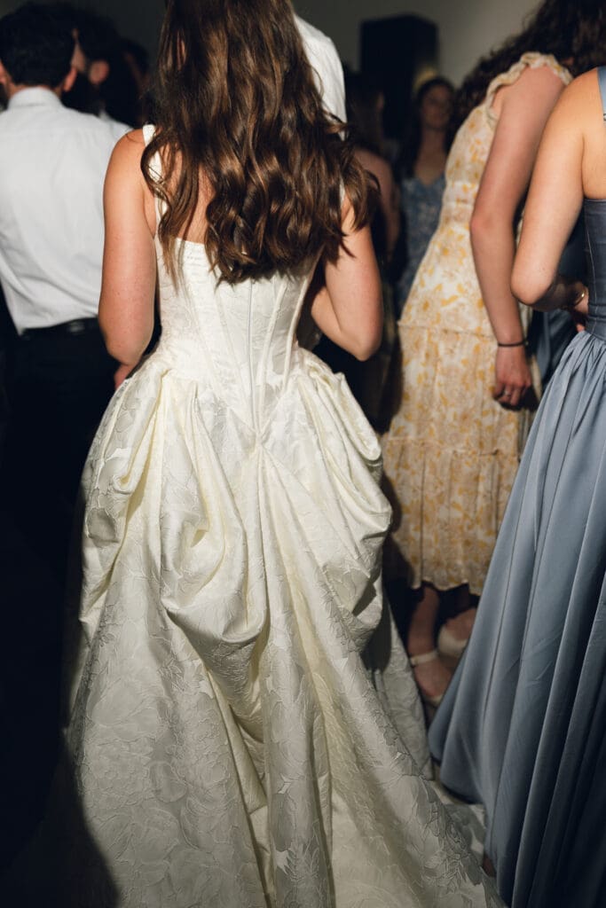 High-contrast direct flash wedding photography from the dance floor showcasing the back details and bustle of the bride's jacquard gown at Longview Mansion.