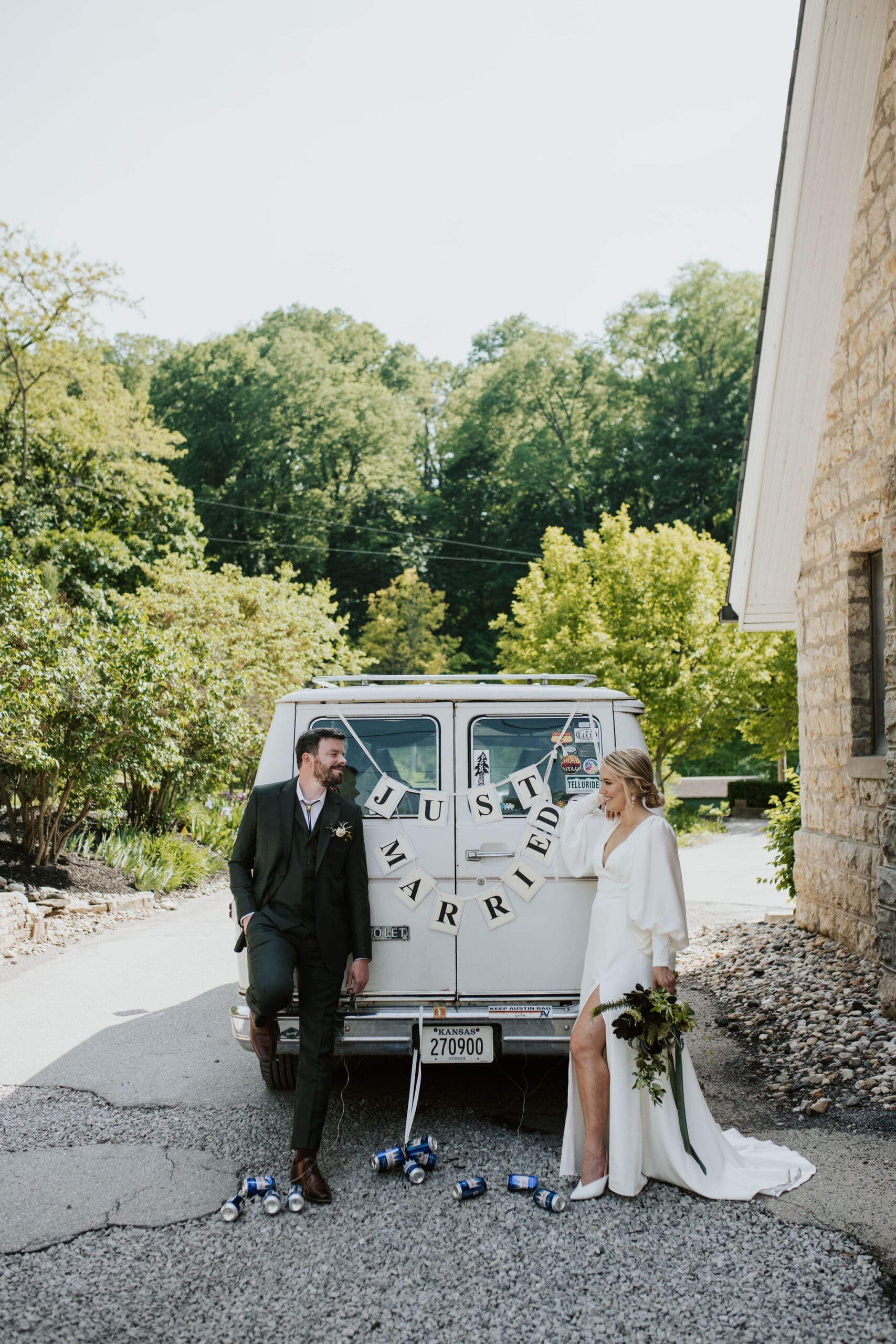 Bride and groom leaving Holy Trinity Catholic Church in a converted travel van after their wedding
