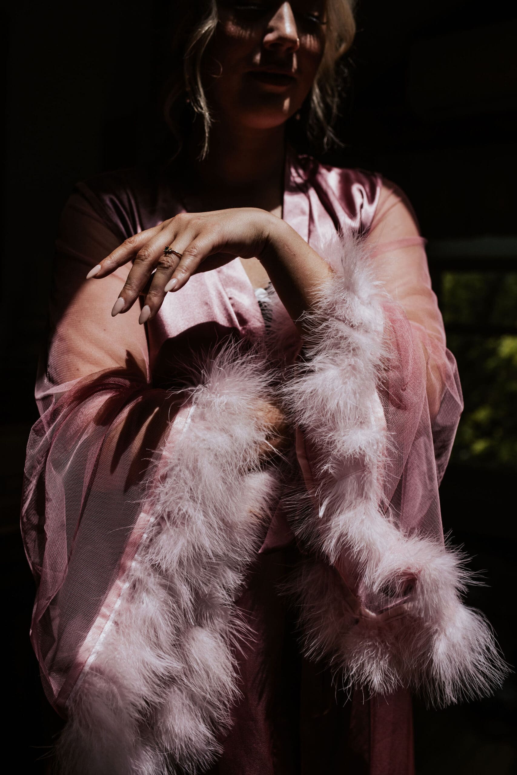 Bride getting ready wearing a pink robe in a wedding venue Weston MO captured by a Kansas City Wedding photographer