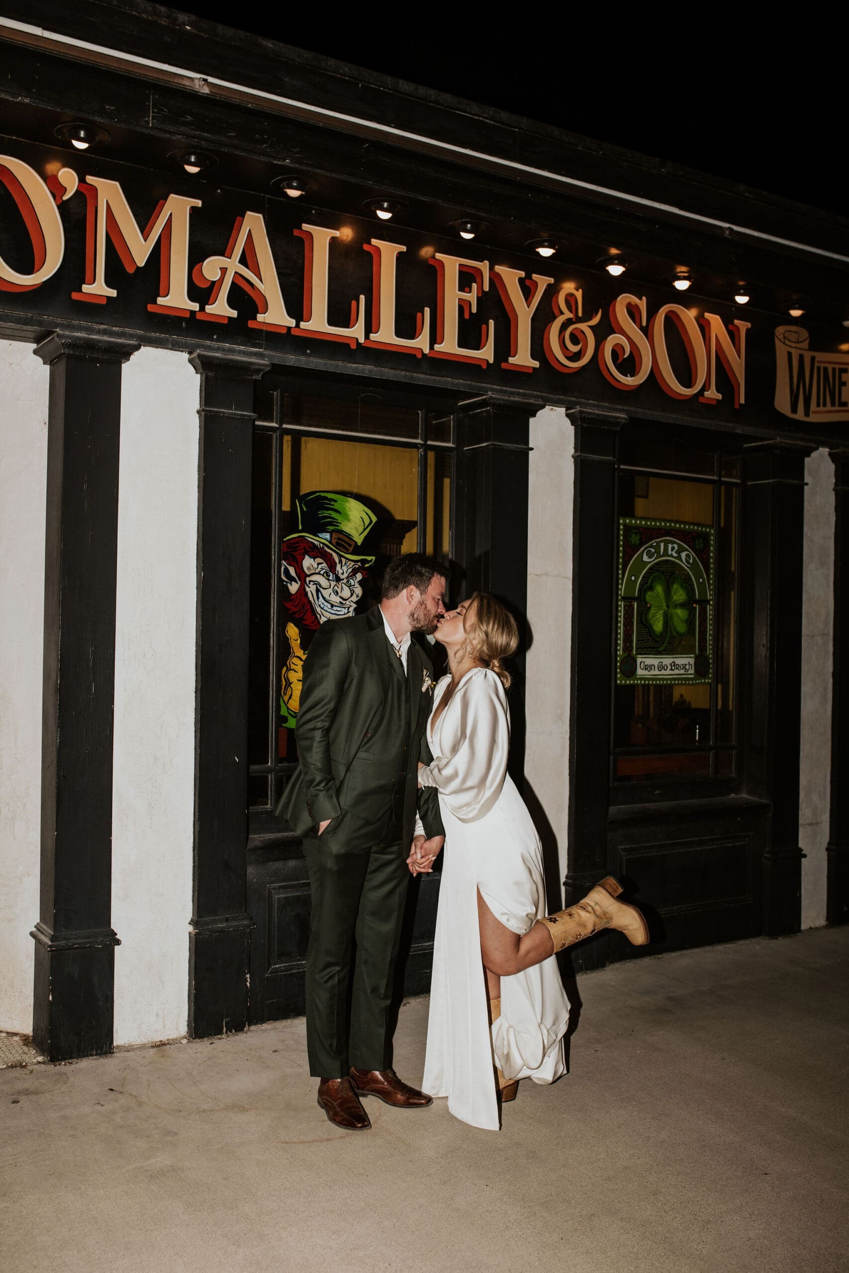 Bride and groom kissing outside O'Malley's Pub in Weston MO