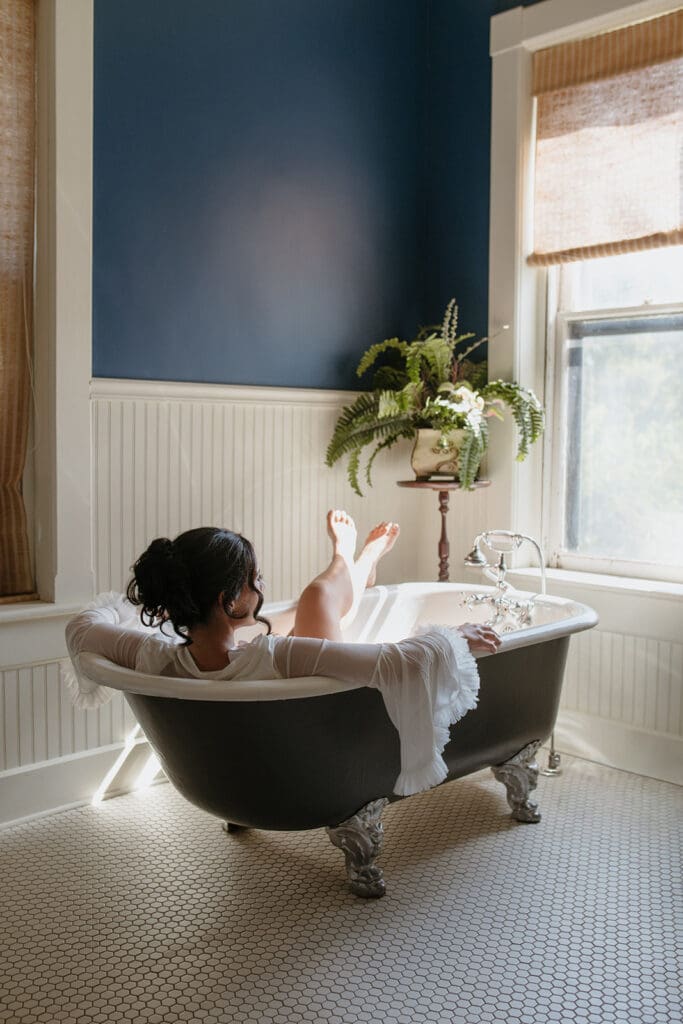 Bride relaxing in a clawfoot tub before her wedding at Our Lady of Guadalupe Catholic Church