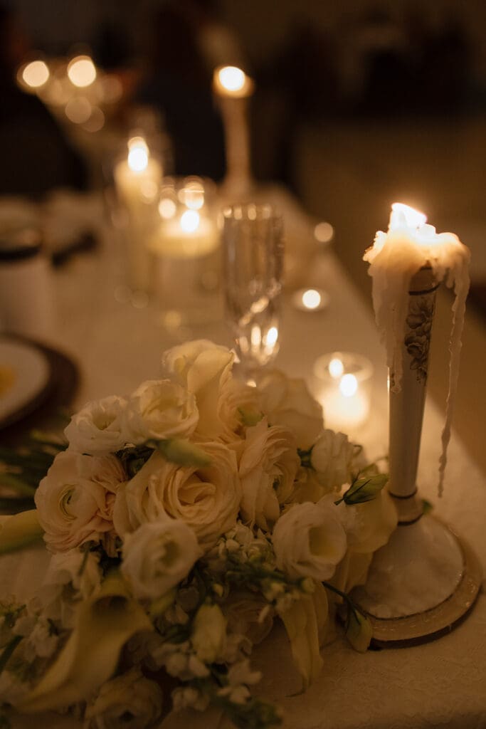 Candlelit reception table with white and blush floral centerpiece