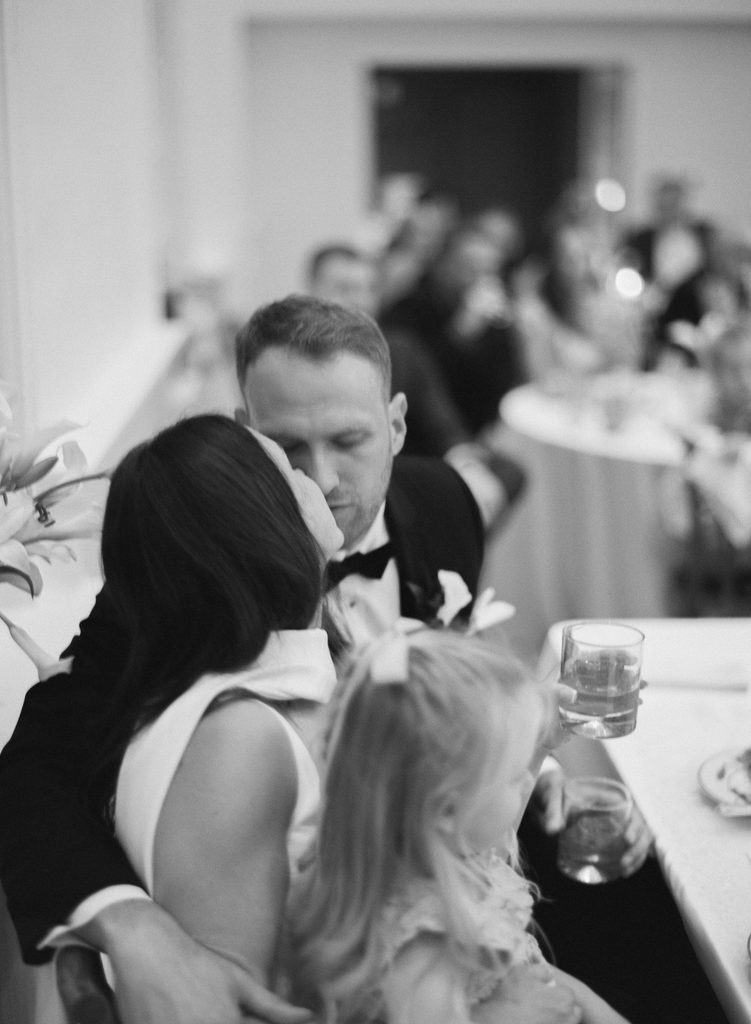 an intimate film photo of a bride and groom kissing at their wedding reception